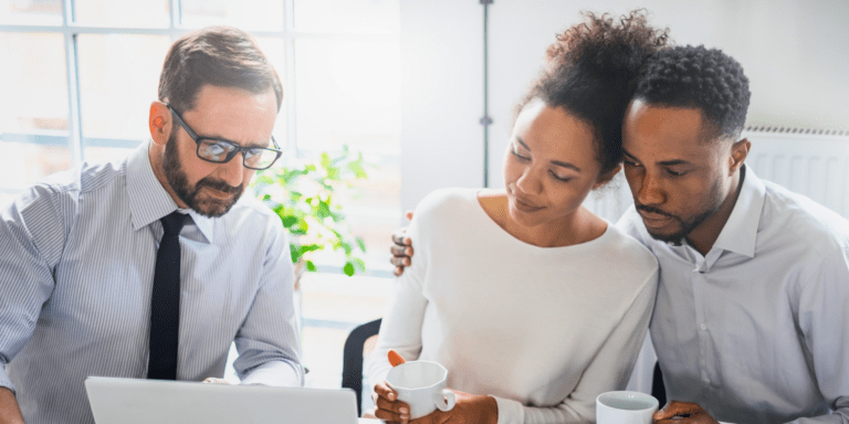 A couple looking over a laptop with a lawyer present.